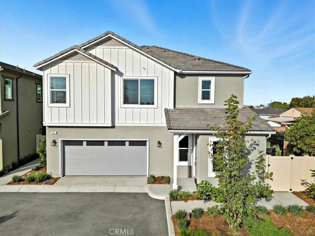 a view of a white house with large windows and a small yard