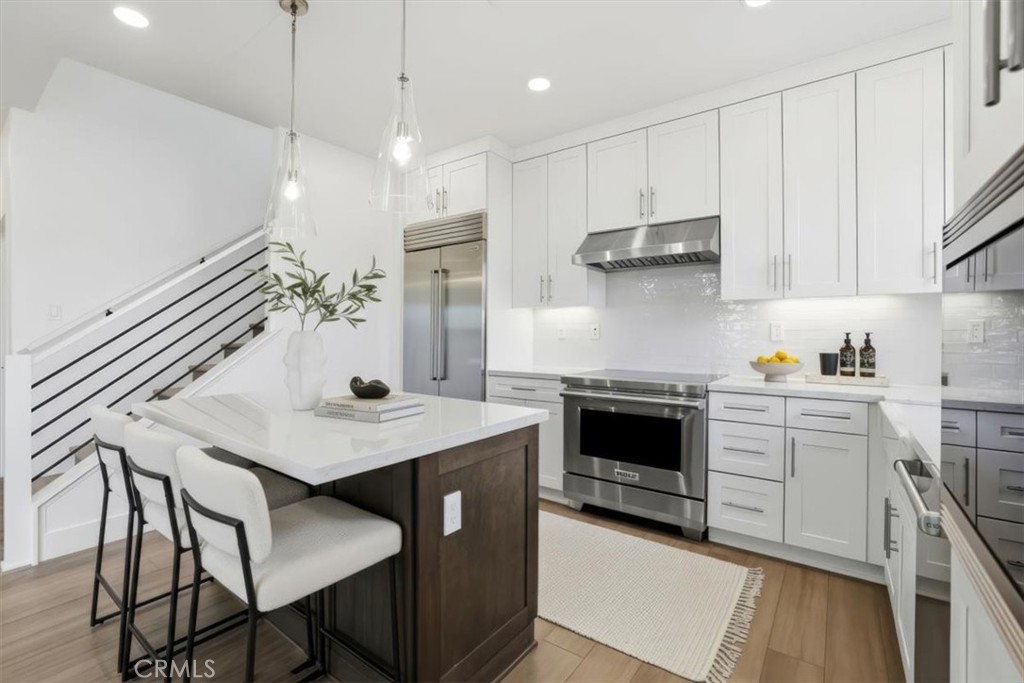 437 Willow Run Lane Carson, CA 90745 - Photo 11 of 37 a kitchen with kitchen island a stove a table a sink and cabinets
