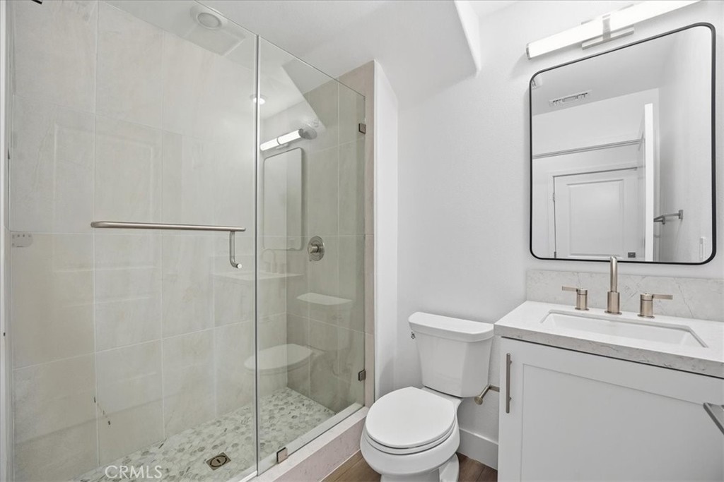 437 Willow Run Lane Carson, CA 90745 - Photo 13 of 37 a bathroom with a toilet sink vanity and shower