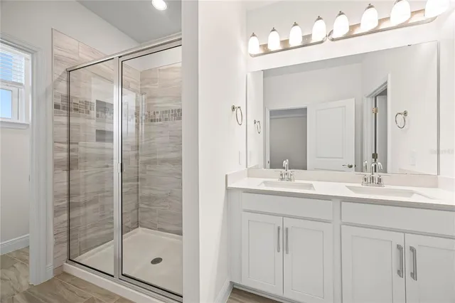 a bathroom with a shower sink and mirror