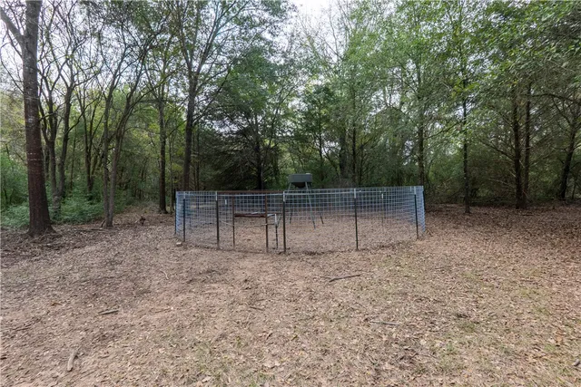 an aerial view of residential house with outdoor space and trees all around