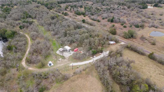 a view of a lake with a big yard and large trees