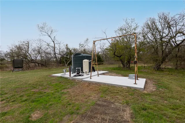 a view of a field with an ocean and trees