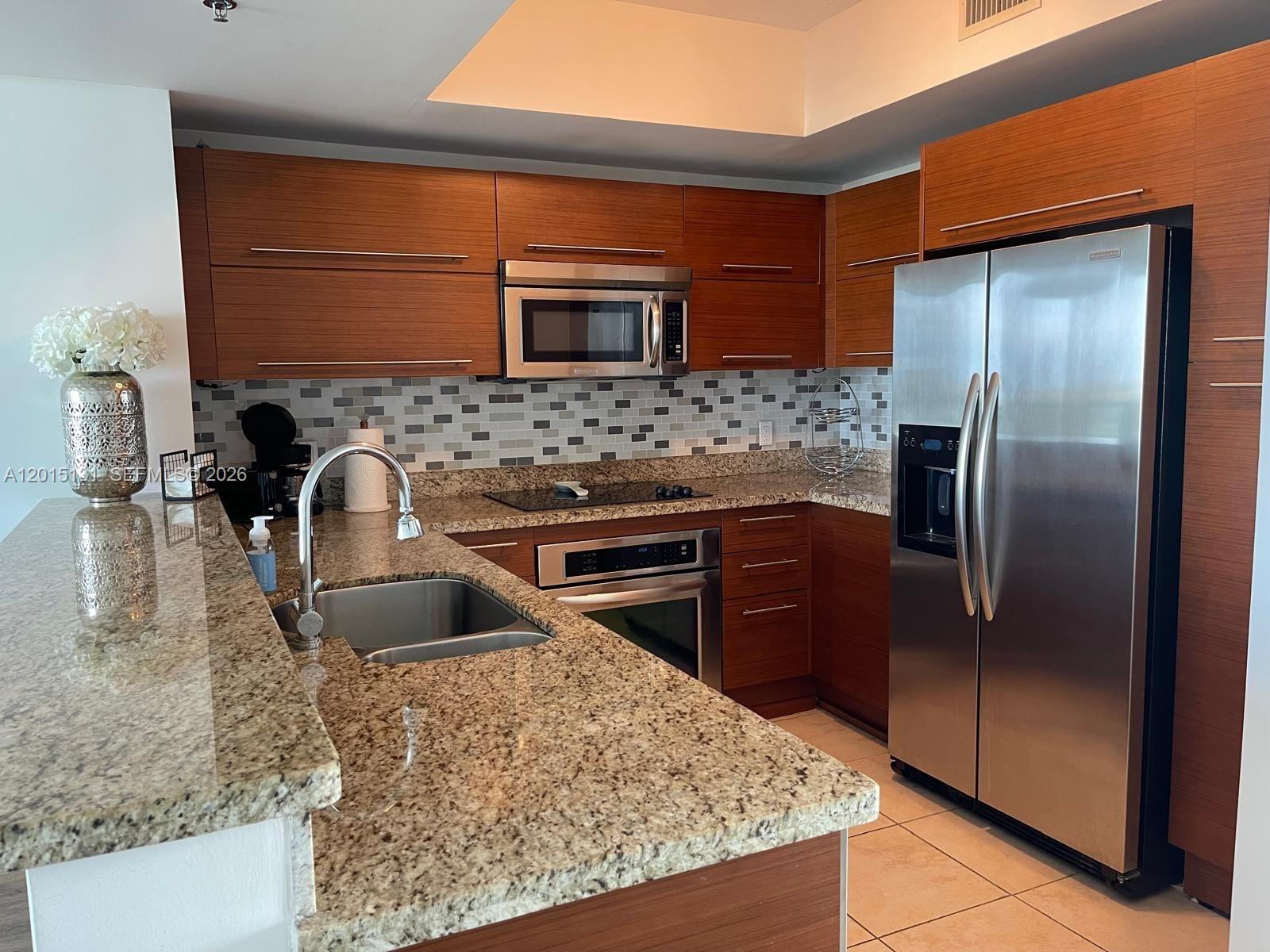 2681 North Flamingo Road, Unit 2004S Sunrise, FL 33323 - Photo 5 of 26 a kitchen with stainless steel appliances granite countertop a sink stove and refrigerator