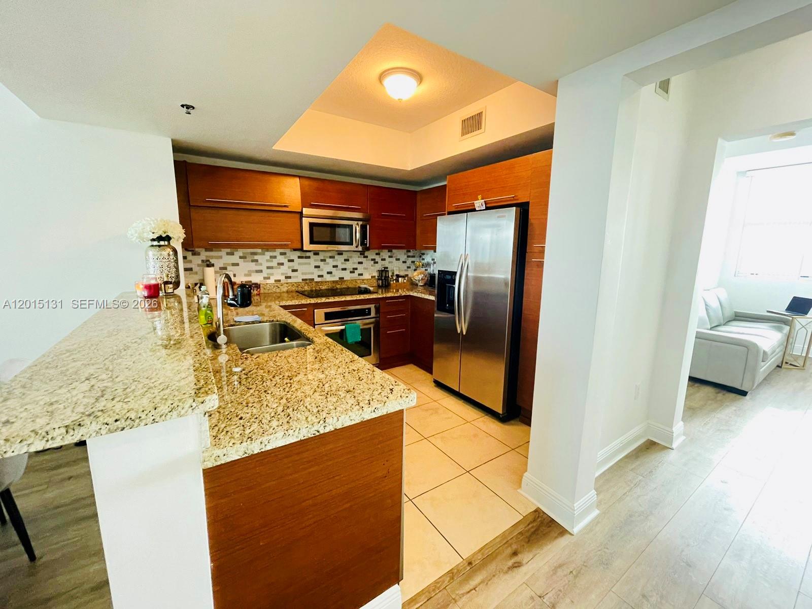 2681 North Flamingo Road, Unit 2004S Sunrise, FL 33323 - Photo 6 of 26 a kitchen with stainless steel appliances granite countertop a sink stove and refrigerator