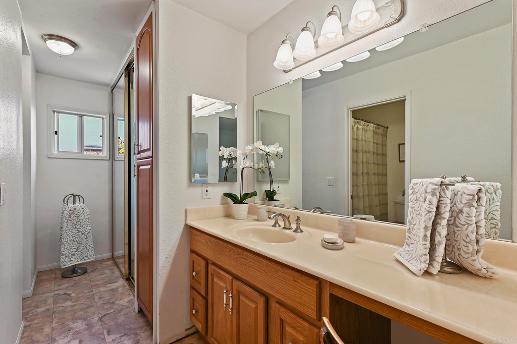 837 Passiflora Avenue Encinitas, CA 92024 - Photo 29 of 42 a bathroom with a sink a large mirror and a shower