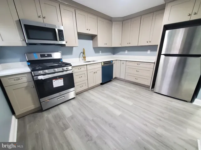 a kitchen with stainless steel appliances white cabinets granite counter tops and a stove