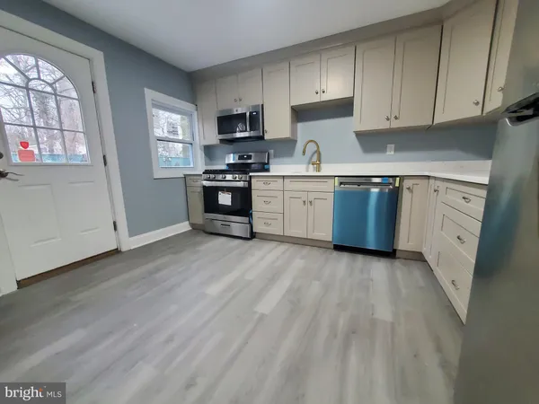 a kitchen with granite countertop a refrigerator stove top oven and sink