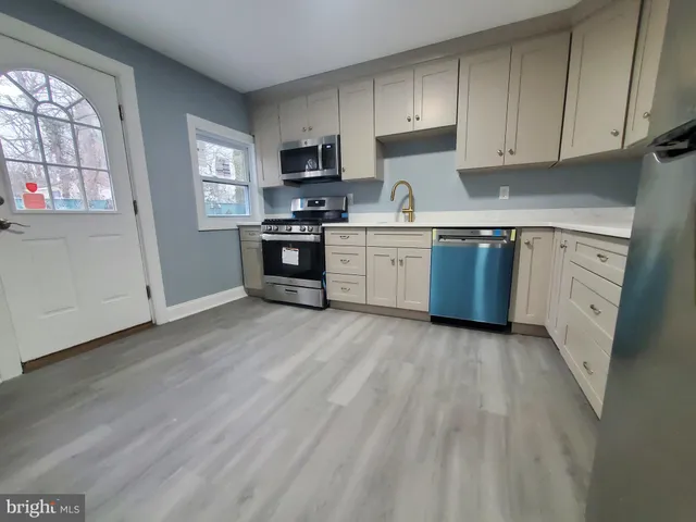 a kitchen with granite countertop a refrigerator stove top oven and sink