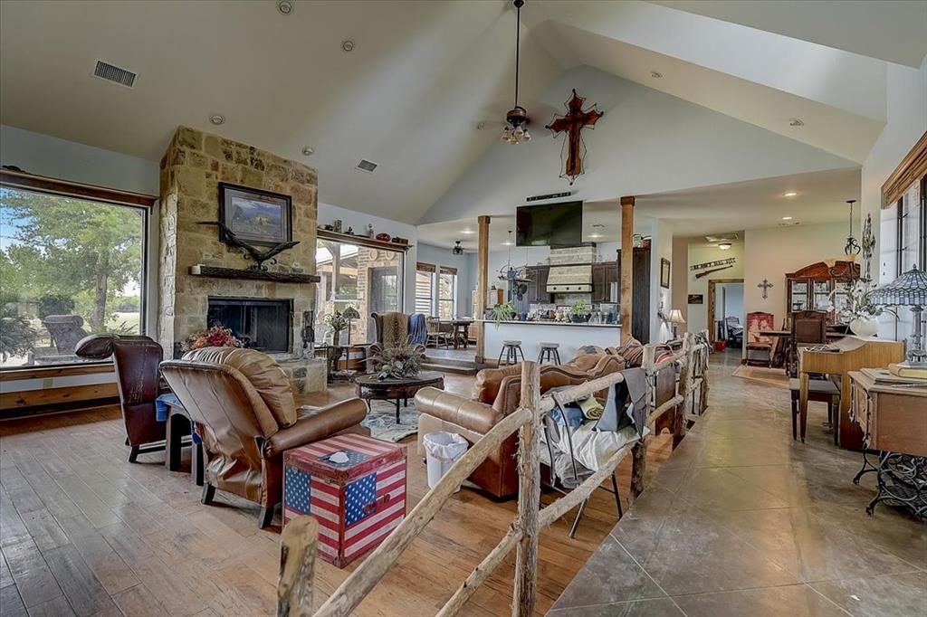9494 Waide Road Sanger, TX 76266 - Photo 10 of 40 Living room featuring a stone fireplace, plenty of natural light, high vaulted ceiling, and wood flooring open concept.