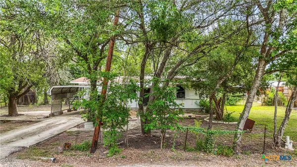 a patio with table and chairs and potted plants