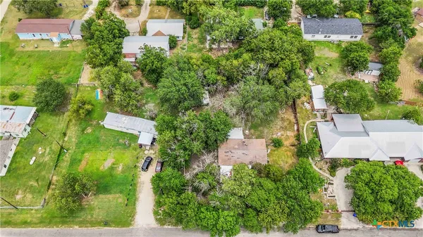 an aerial view of residential house with outdoor space and trees all around
