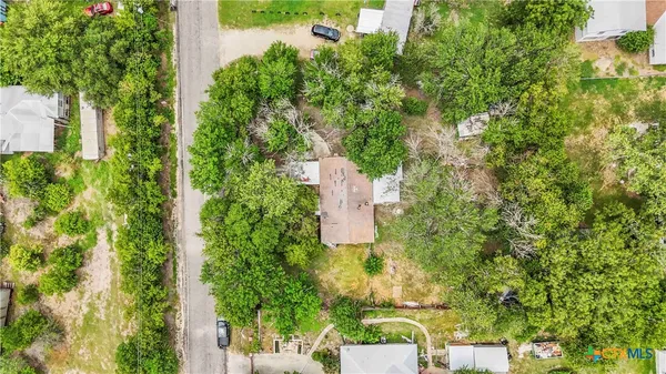 an aerial view of residential house with outdoor space and trees all around