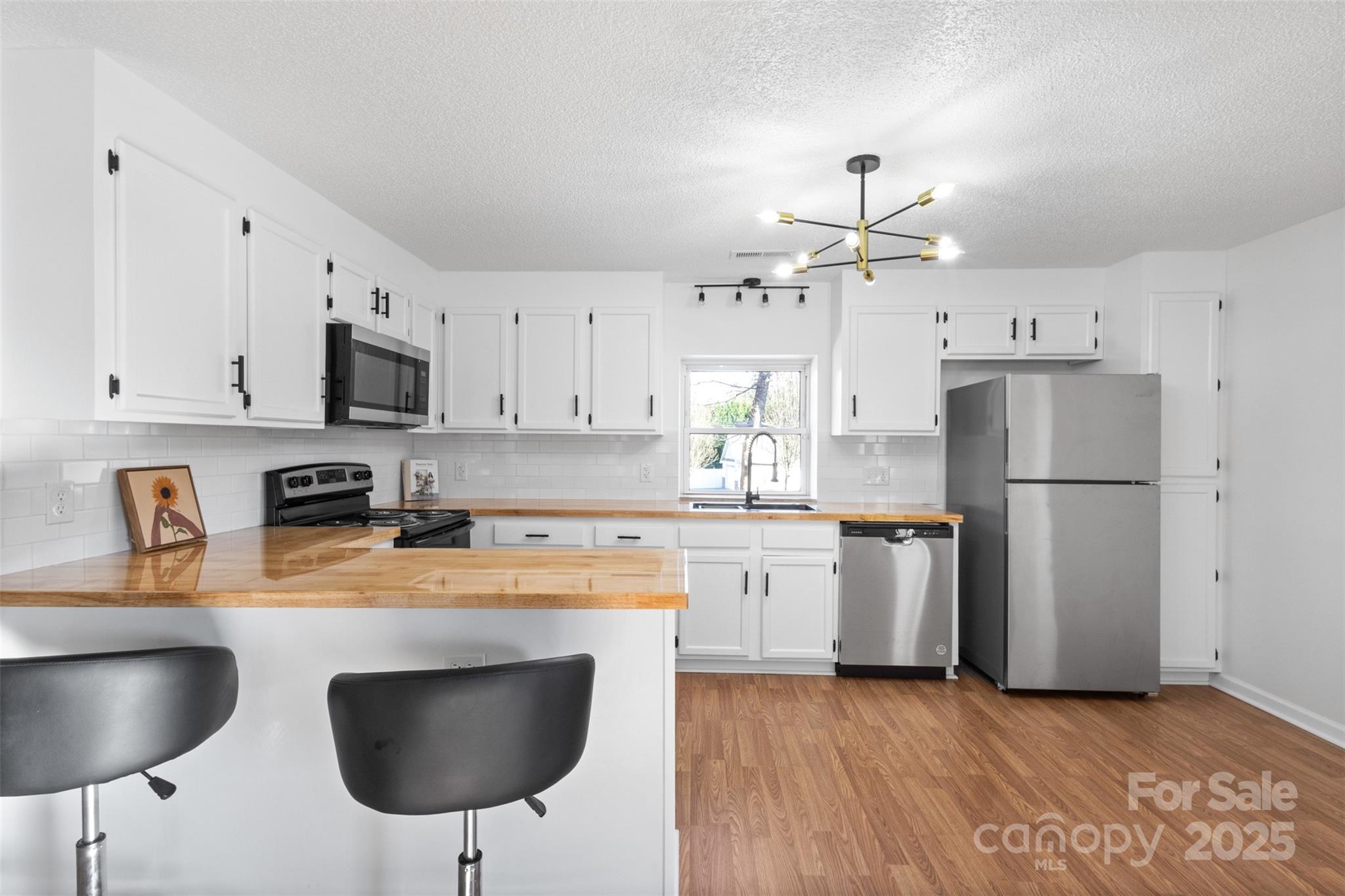 717 Perth Road Troutman, NC 28166 - Photo 5 of 15 a kitchen with stainless steel appliances granite countertop a stove refrigerator sink and cabinets