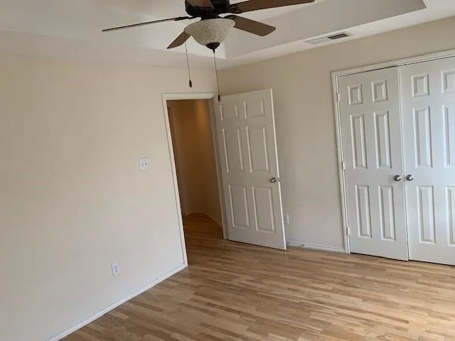 a view of empty room with wooden floor