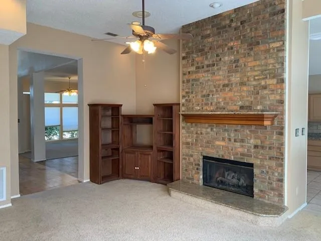 an empty room with fireplace cabinet and windows