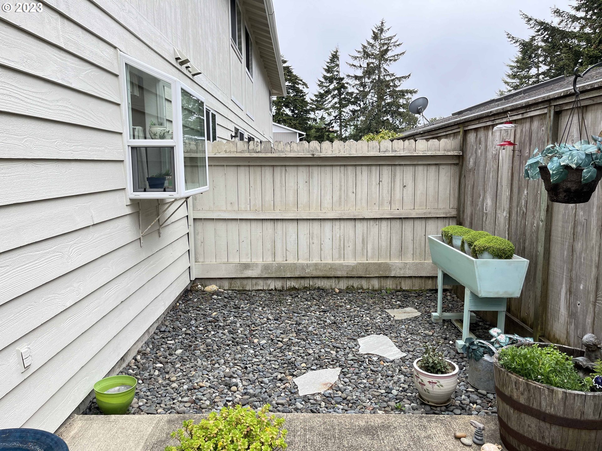 1340 9th Street, Unit 4 Florence, OR 97439 - Photo 19 of 31 a view of a backyard with chair and potted plants