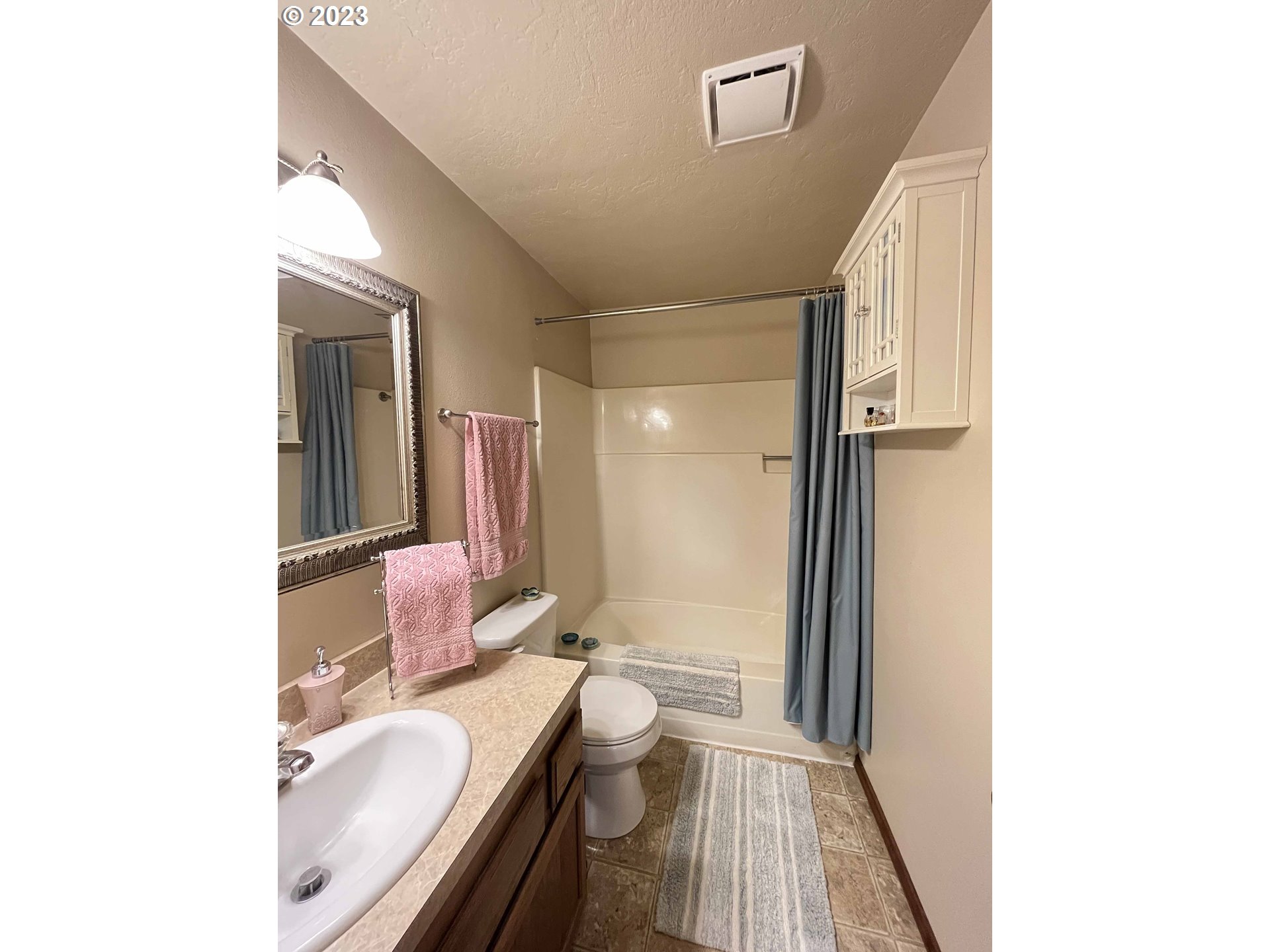 1340 9th Street, Unit 4 Florence, OR 97439 - Photo 21 of 31 a bathroom with a granite countertop sink mirror vanity and toilet