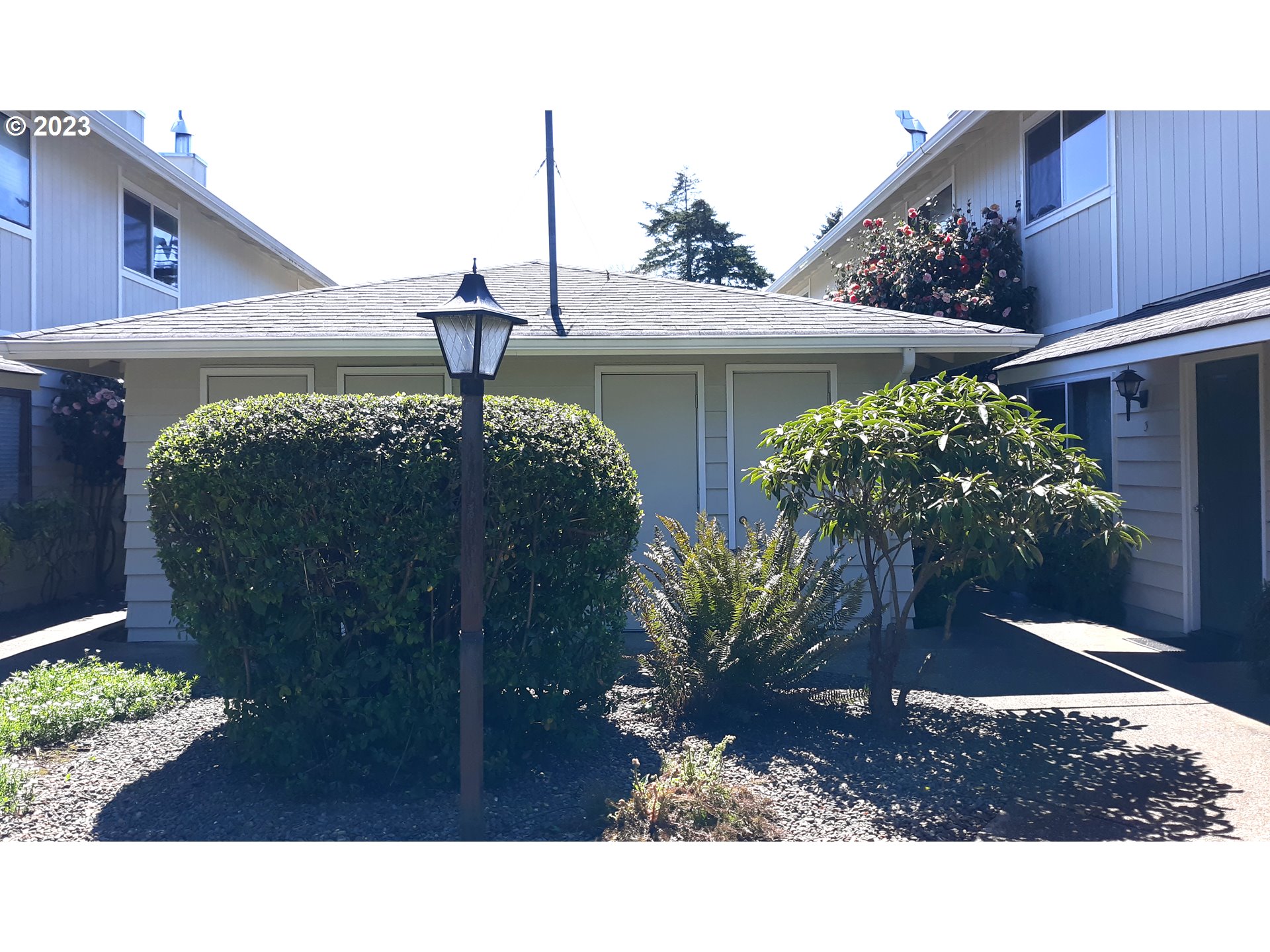 1340 9th Street, Unit 4 Florence, OR 97439 - Photo 27 of 31 a black and white house with a yard