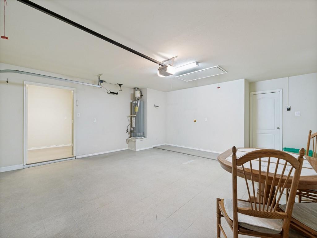 10032 Bell Rock Road Frisco, TX 75035 - Photo 21 of 23 Spacious garage featuring light-colored flooring, white walls, an 8X8 storage room, and an accessible water heater.