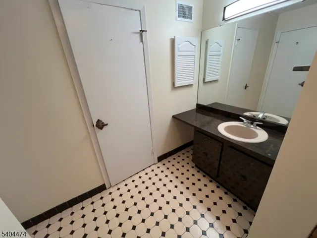 a bathroom with a sink a toilet a mirror and shower