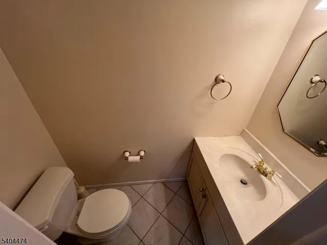 a bathroom with a sink vanity mirror and toilet