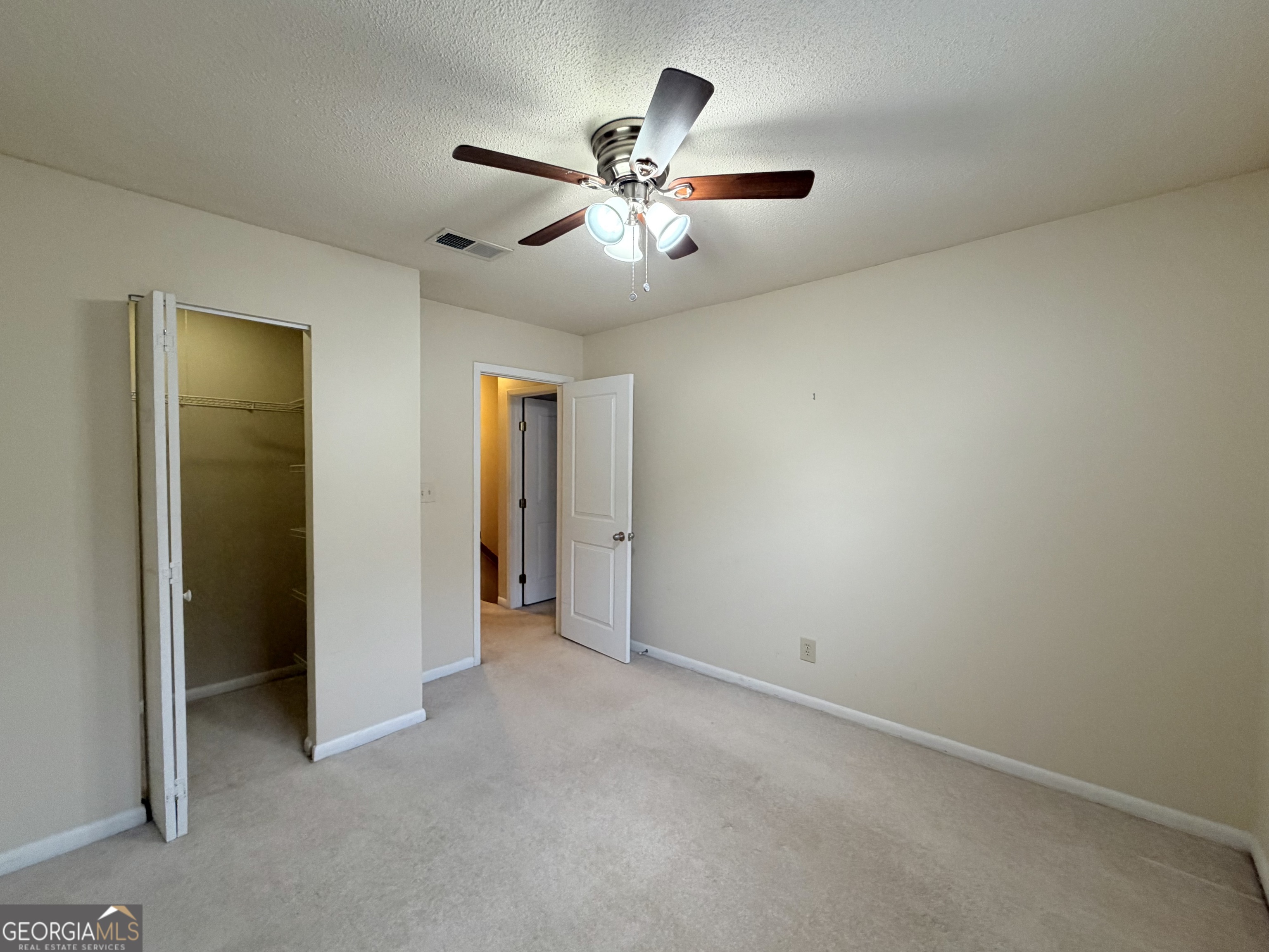 6900 Roswell Road Atlanta, GA 30328 - Photo 15 of 19 an empty room with closet and a ceiling fan