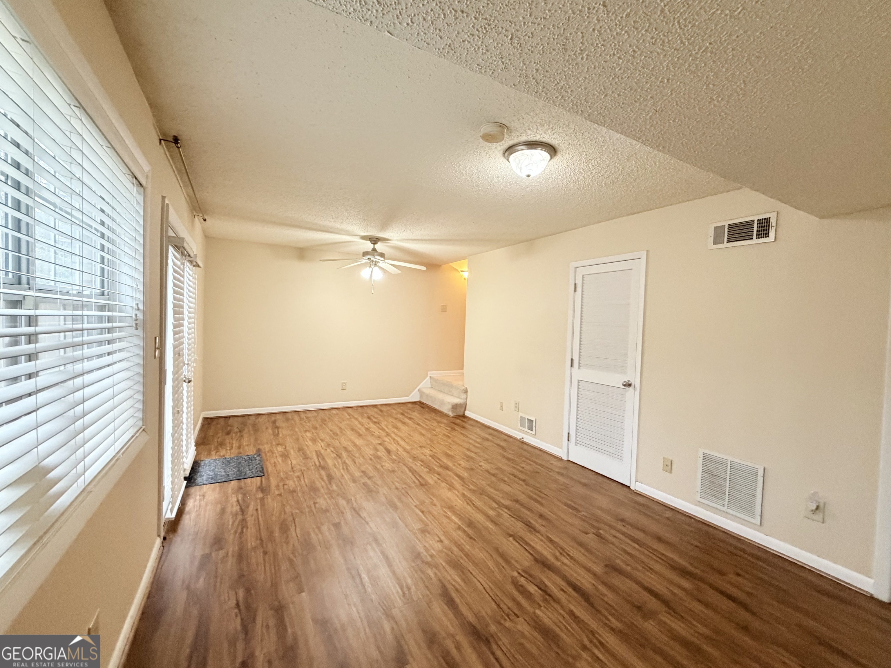6900 Roswell Road Atlanta, GA 30328 - Photo 18 of 19 a view of empty room with wooden floor and fan