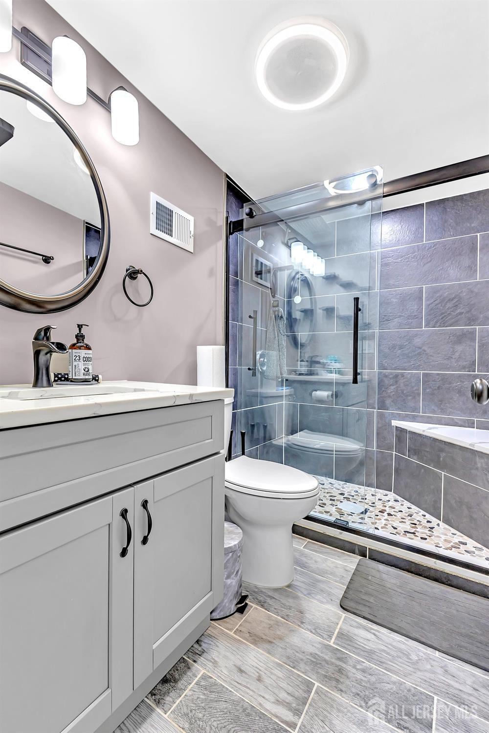 123 Highfield Road Colonia, NJ 07067 - Photo 16 of 30 a bathroom with a toilet a sink and mirror