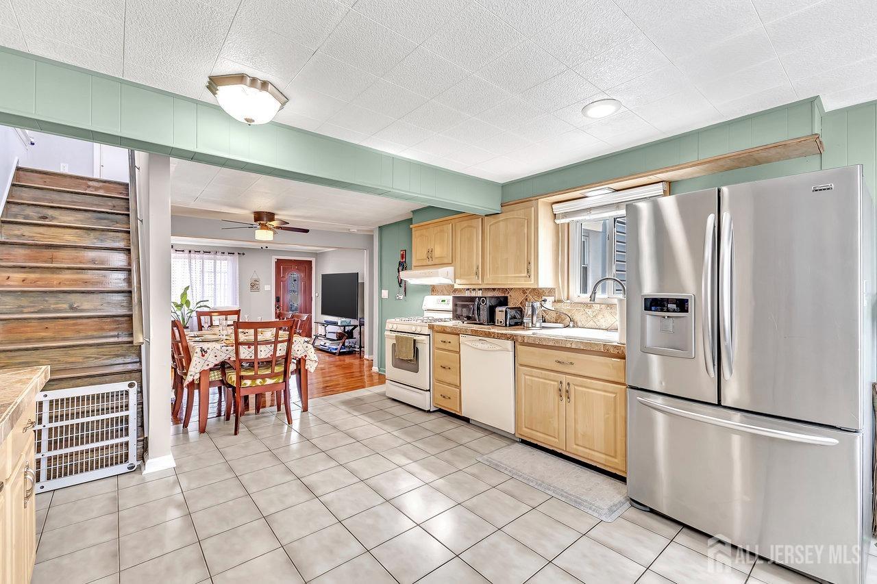 123 Highfield Road Colonia, NJ 07067 - Photo 10 of 30 a kitchen with a refrigerator a table and chairs