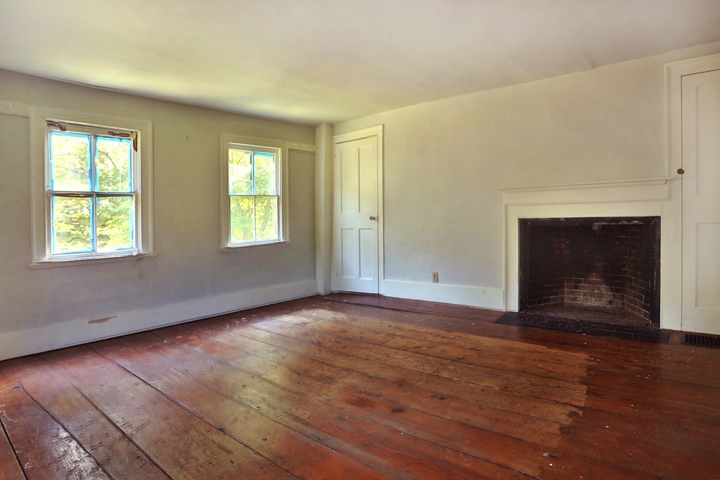 82 Baldpate Road Boxford, MA 01921 - Photo 12 of 20 an empty room with wooden floor fireplace and windows