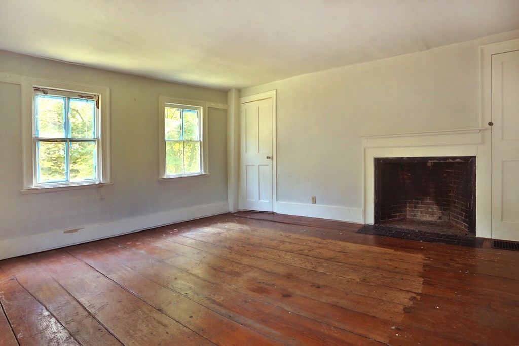 82 Baldpate Road Boxford, MA 01921 - Photo 7 of 20 an empty room with wooden floor fireplace and windows