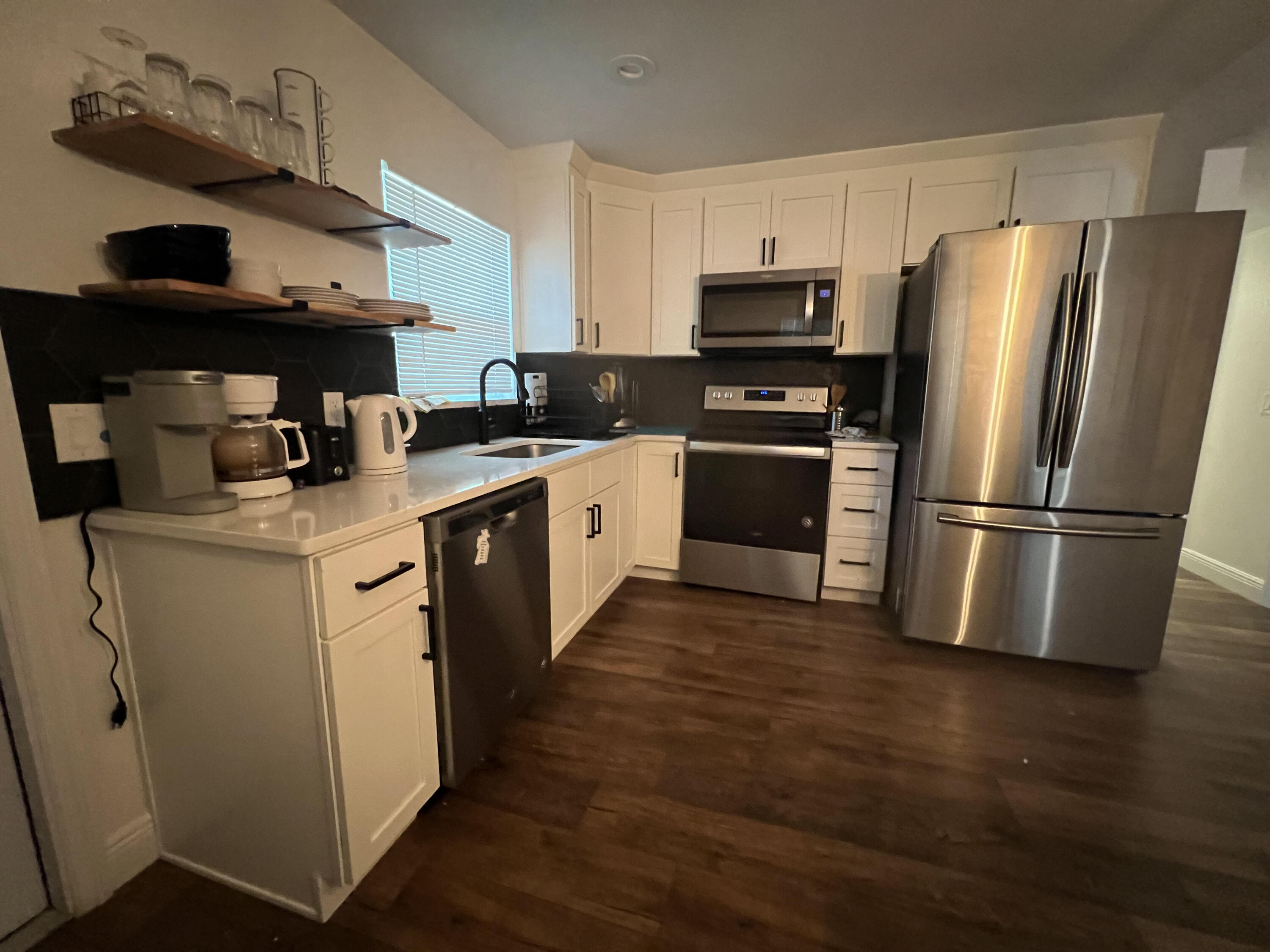 2807 South Vassar Street Melbourne, FL 32901 - Photo 6 of 12 a kitchen with a sink wooden floor and stainless steel appliances
