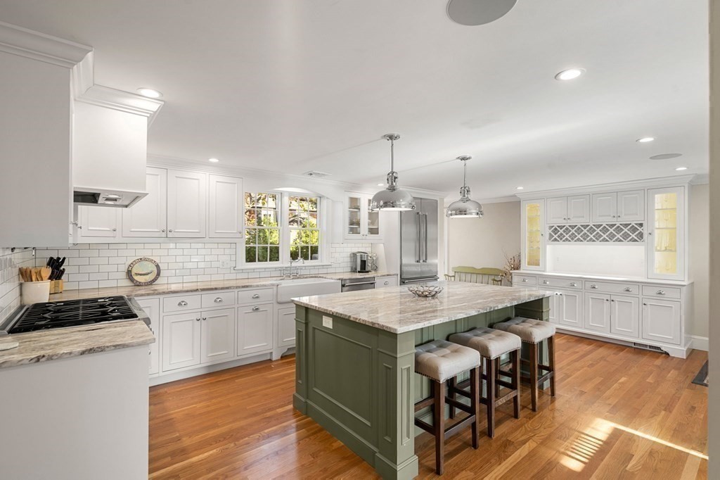20 Shetland Road Marblehead, MA 01945 - Photo 14 of 40 a kitchen with a stove a sink a refrigerator and white cabinets with wooden floor