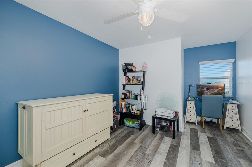 4516 Seagull Drive, Unit 615 New Port Richey, FL 34652 - Photo 20 of 45 a bedroom with a bed and a chandelier