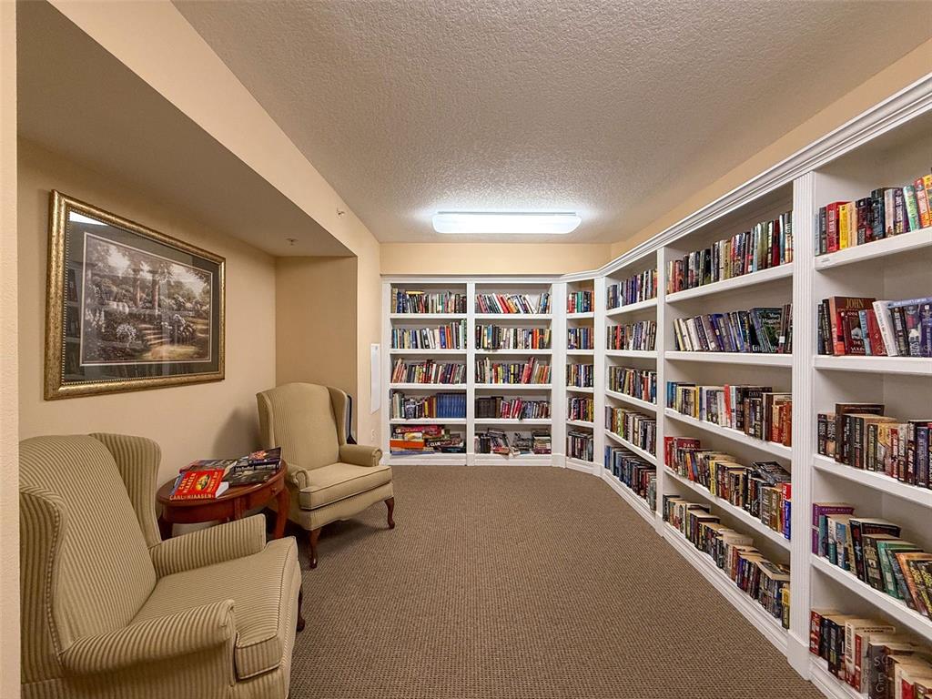 4516 Seagull Drive, Unit 615 New Port Richey, FL 34652 - Photo 31 of 45 a living room with furniture and a book shelf