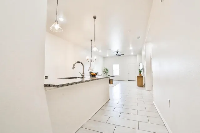 a large kitchen with kitchen island white cabinets and sink