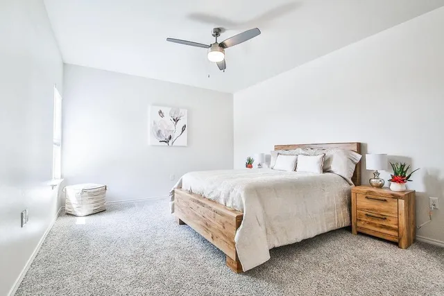 a bedroom with a bed and a painting on the wall