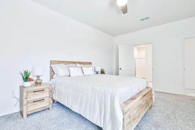 a spacious bedroom with a bed and a window