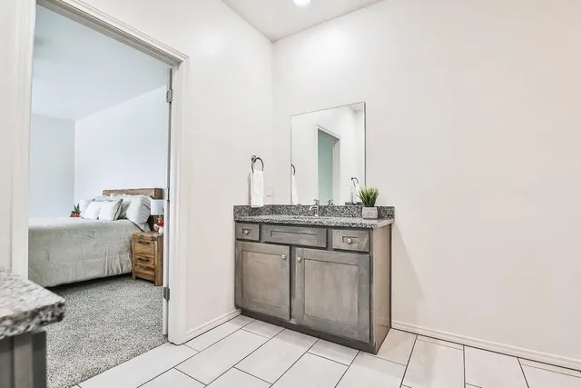 a bathroom with a granite countertop sink and a mirror
