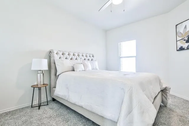 a bedroom with a bed and a night stand