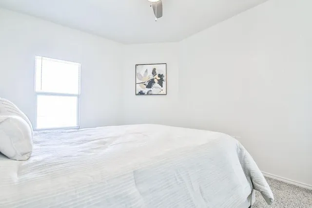 a view of a bedroom with a bed and a window