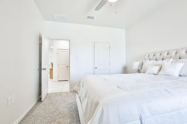 a bedroom with a bed and a white cabinet