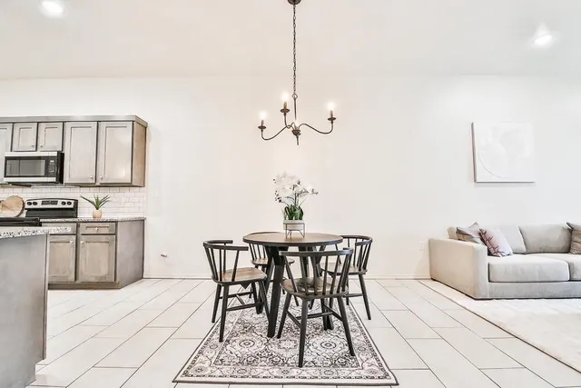 a living room with furniture a rug and kitchen view