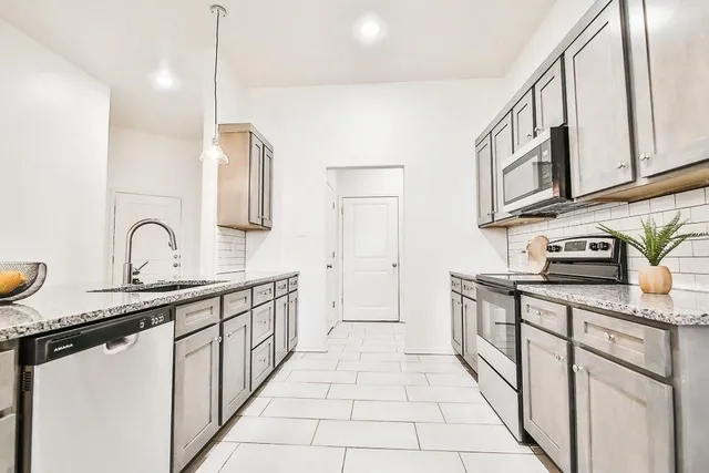 a kitchen with stainless steel appliances granite countertop a sink and cabinets