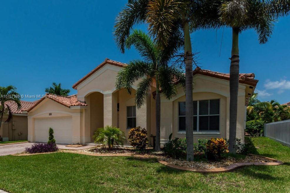 a front view of a house with a garden and plants