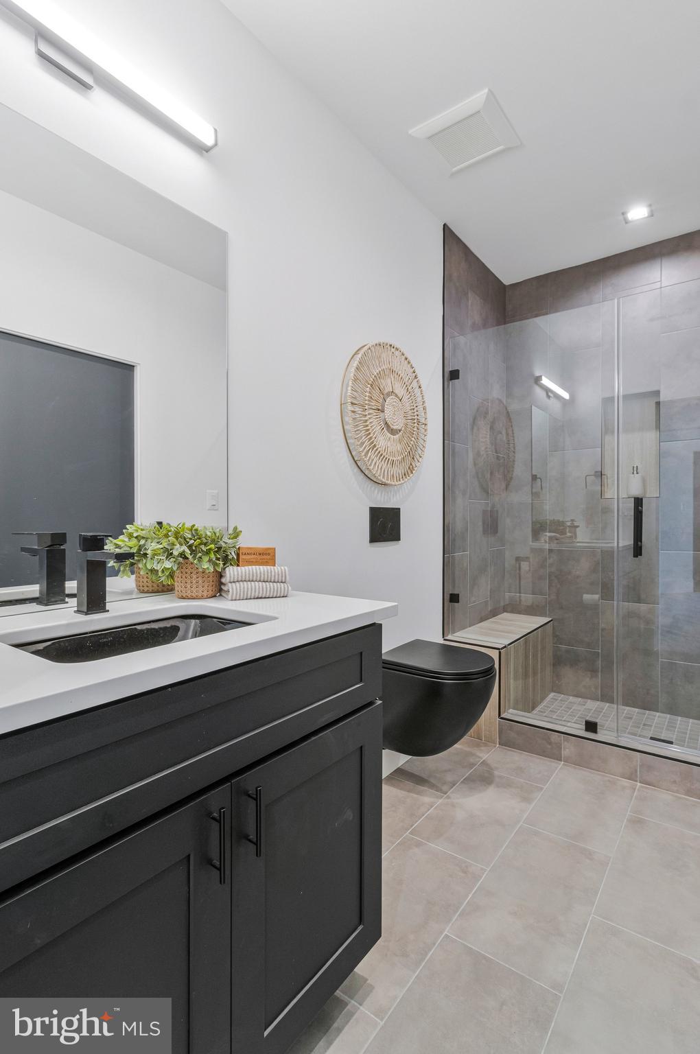 3525 Glenbrook Road Fairfax, VA 22031 - Photo 90 of 111 a bathroom with a granite countertop sink a toilet a mirror and shower