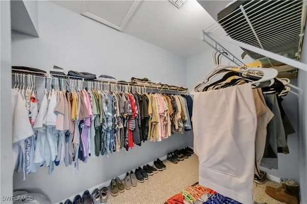 a view of walk in closet with clothes and shoes