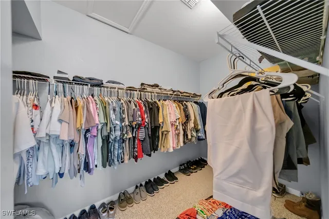 a view of walk in closet with clothes and shoes