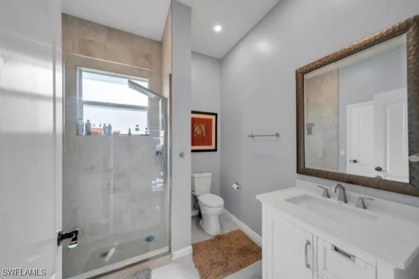 a bathroom with a sink a toilet and shower